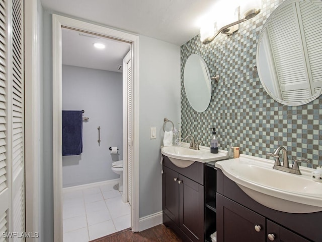 bathroom with tile patterned floors, vanity, toilet, and tasteful backsplash