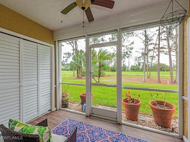 unfurnished sunroom with ceiling fan