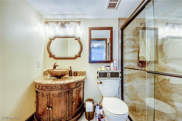 bathroom featuring vanity, toilet, and a shower with door