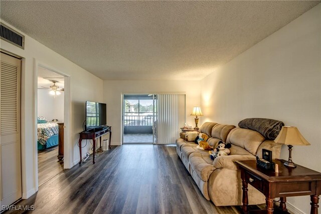 living room featuring a textured ceiling and dark hardwood / wood-style floors