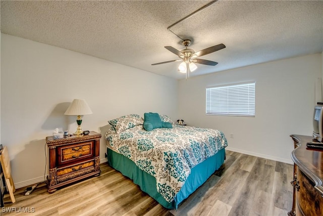 bedroom with wood-type flooring, a textured ceiling, and ceiling fan