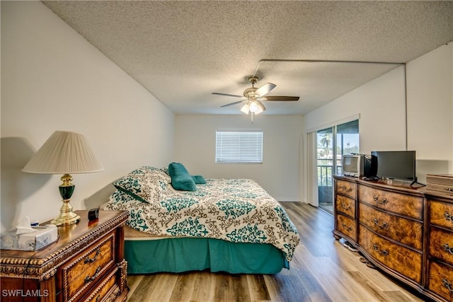 bedroom with access to exterior, light wood-type flooring, a textured ceiling, and ceiling fan