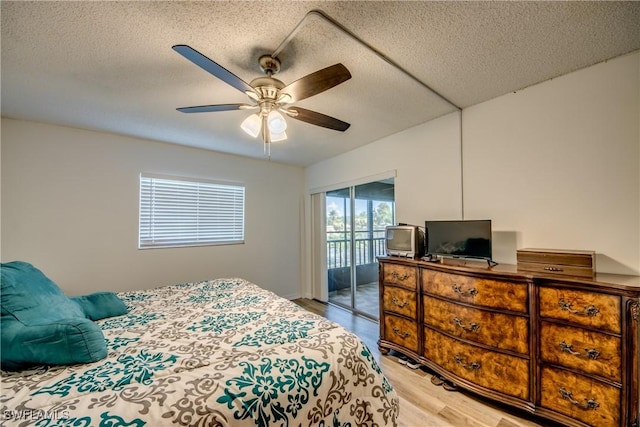 bedroom featuring access to outside, ceiling fan, wood-type flooring, and a textured ceiling