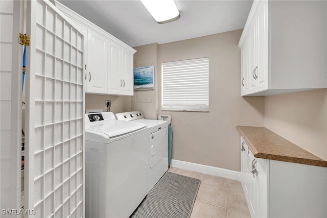 laundry area with cabinets, independent washer and dryer, and light tile patterned floors