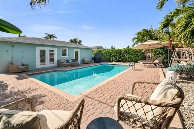 view of swimming pool with outdoor lounge area, french doors, and a patio area