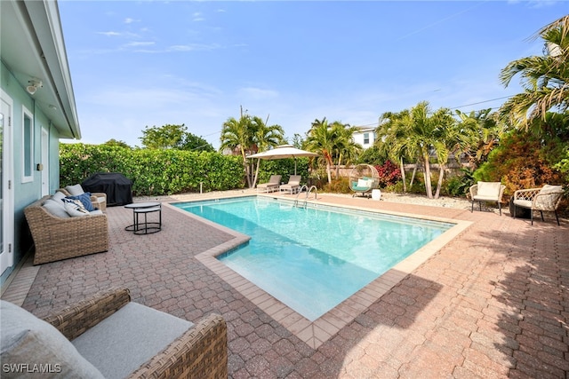 view of pool with a patio and a grill