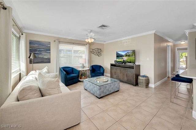 tiled living room featuring a healthy amount of sunlight, ceiling fan, and crown molding