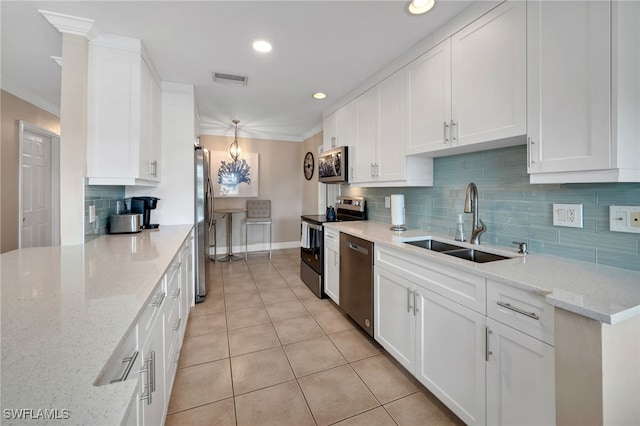 kitchen with light stone countertops, stainless steel appliances, sink, light tile patterned floors, and white cabinetry