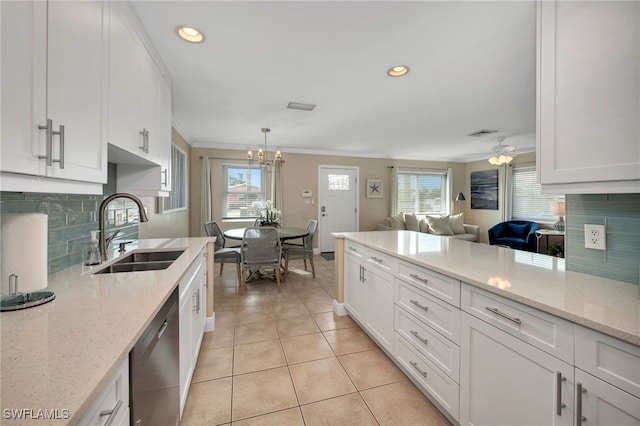 kitchen featuring ceiling fan with notable chandelier, sink, stainless steel dishwasher, decorative light fixtures, and white cabinetry