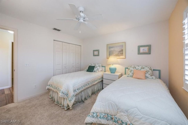 bedroom with ceiling fan, visible vents, baseboards, a closet, and carpet