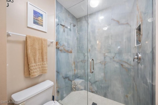 bathroom with a marble finish shower and toilet