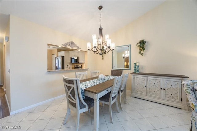 dining space featuring light tile patterned floors, baseboards, vaulted ceiling, and a notable chandelier