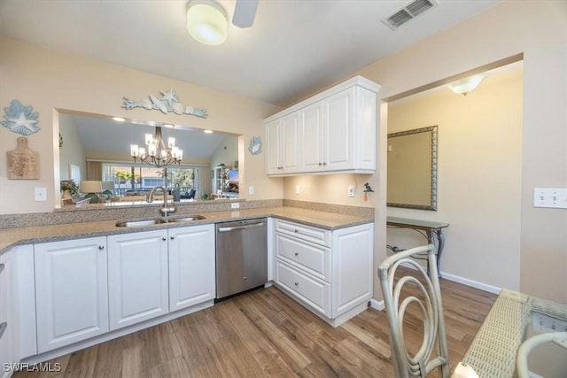 kitchen with visible vents, stainless steel dishwasher, white cabinets, a sink, and wood finished floors