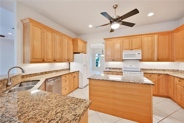 kitchen with light stone countertops, white appliances, a kitchen island, sink, and light tile patterned floors