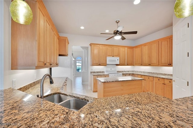 kitchen featuring decorative light fixtures, ceiling fan, sink, white appliances, and light stone counters