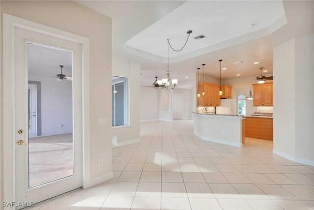 kitchen featuring decorative light fixtures, light tile patterned floors, a raised ceiling, and white fridge