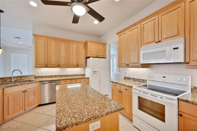 kitchen featuring a kitchen island, sink, white appliances, light tile patterned floors, and light stone counters