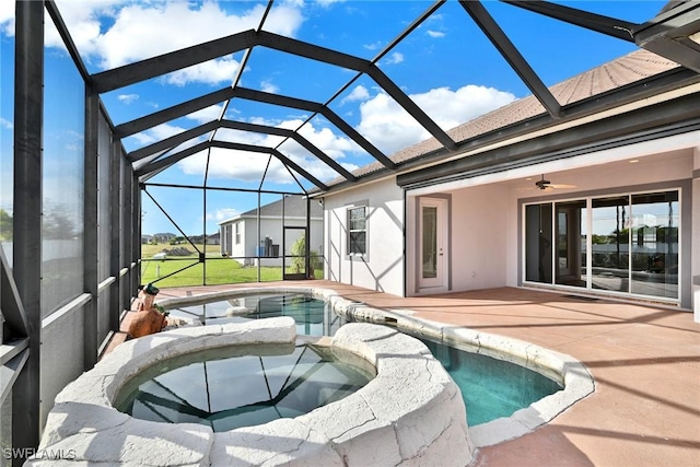 view of swimming pool with ceiling fan, a patio area, glass enclosure, and an in ground hot tub