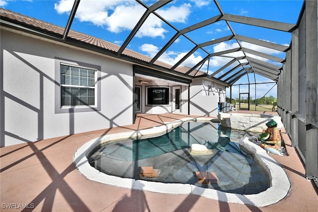 view of swimming pool featuring ceiling fan, glass enclosure, and a patio area