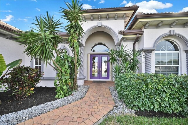 entrance to property with french doors and stucco siding