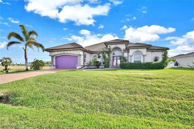 mediterranean / spanish home with a garage, a front yard, and french doors