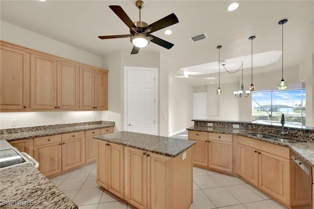 kitchen featuring a kitchen island, light brown cabinetry, and sink