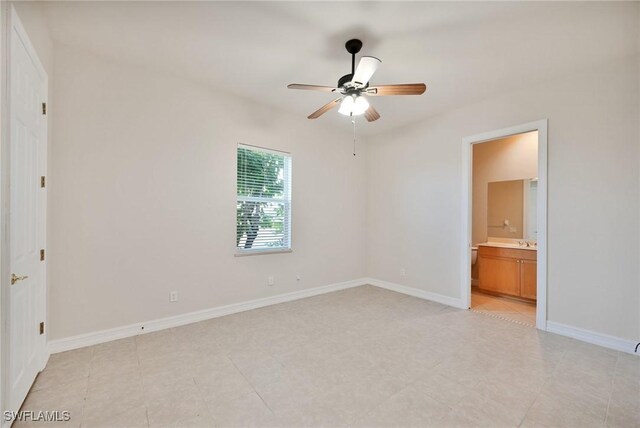 unfurnished bedroom featuring ceiling fan and connected bathroom