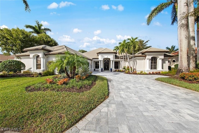 mediterranean / spanish house featuring a front lawn