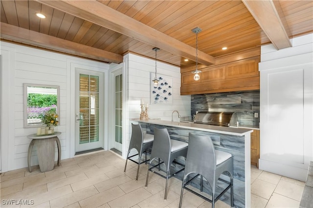 kitchen with wood ceiling, kitchen peninsula, beamed ceiling, and pendant lighting