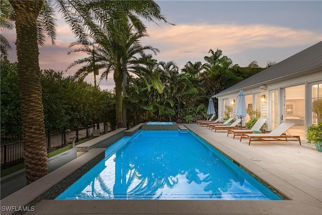 pool at dusk with a patio