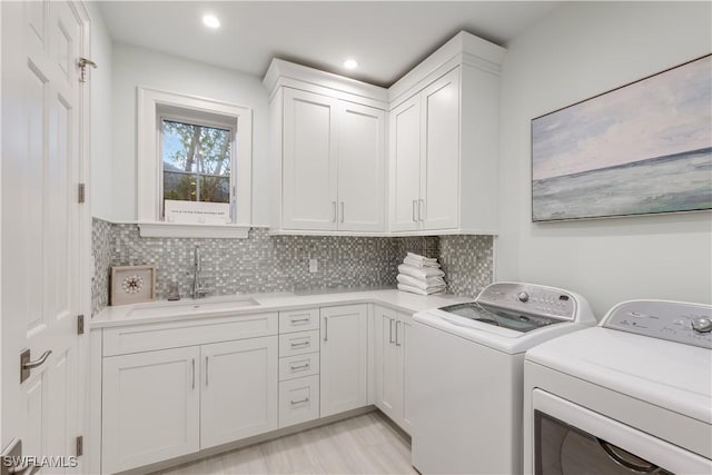 laundry room featuring cabinets, washer and clothes dryer, and sink