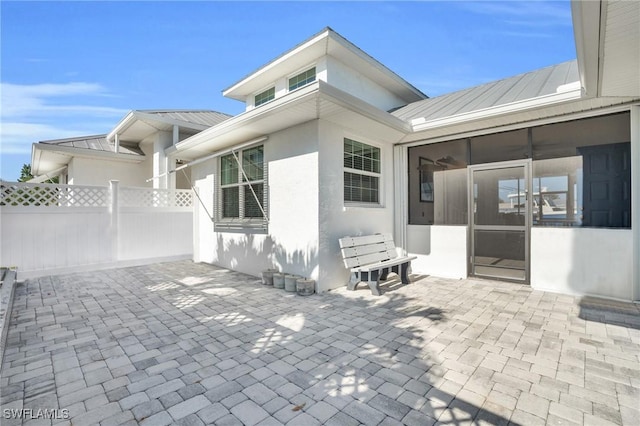 view of patio / terrace with a sunroom and fence