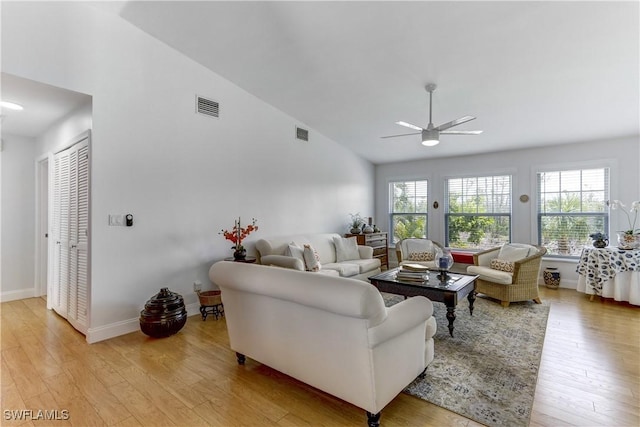 living room featuring ceiling fan, light wood-type flooring, lofted ceiling, and plenty of natural light