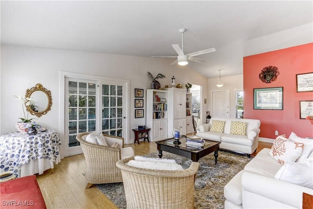 living room with light hardwood / wood-style floors, ceiling fan, and lofted ceiling