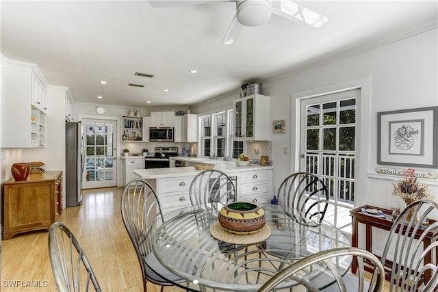 dining area with light hardwood / wood-style floors, ceiling fan, and crown molding