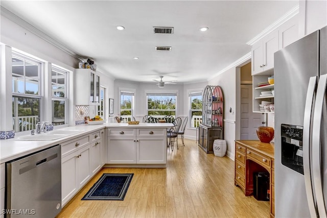 kitchen with white cabinetry, sink, ceiling fan, kitchen peninsula, and appliances with stainless steel finishes