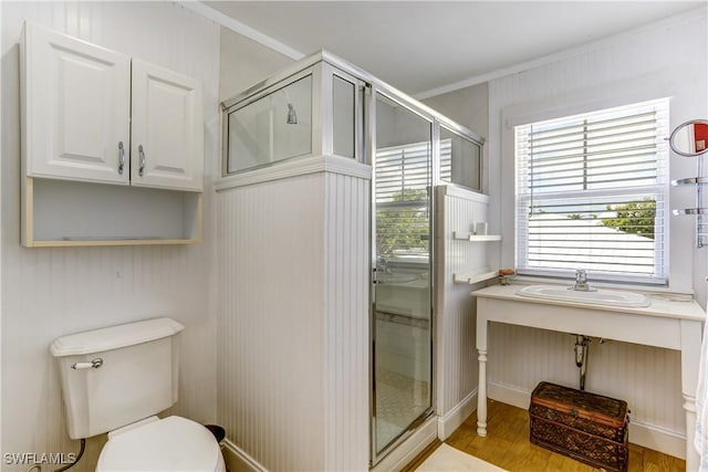 bathroom with sink, hardwood / wood-style flooring, toilet, ornamental molding, and an enclosed shower