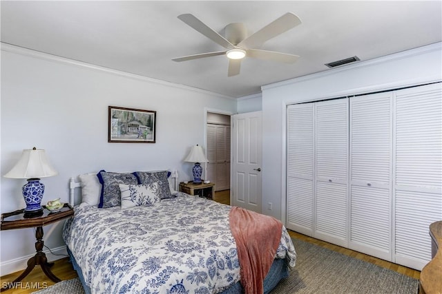 bedroom featuring ceiling fan, a closet, wood-type flooring, and ornamental molding