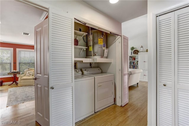 laundry room with washer and dryer and light wood-type flooring