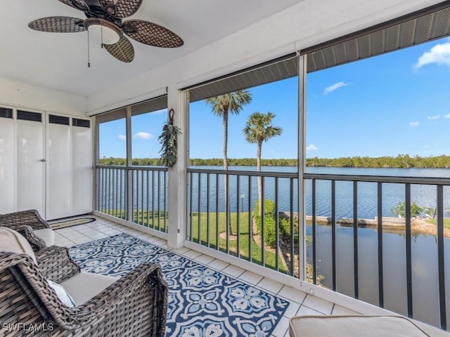 sunroom / solarium featuring ceiling fan and a water view