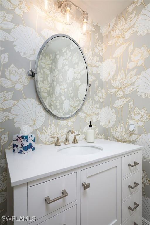 bathroom featuring vanity and wallpapered walls