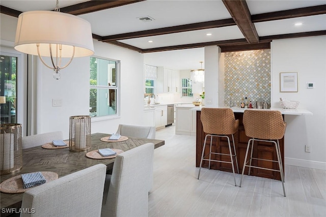 dining area featuring visible vents, beamed ceiling, a healthy amount of sunlight, and baseboards