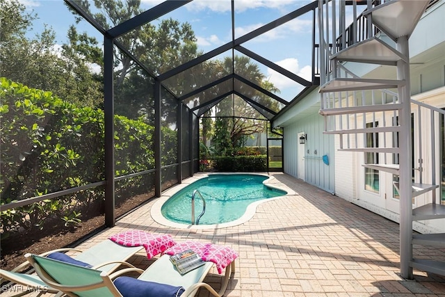 outdoor pool featuring a lanai, stairs, and a patio area