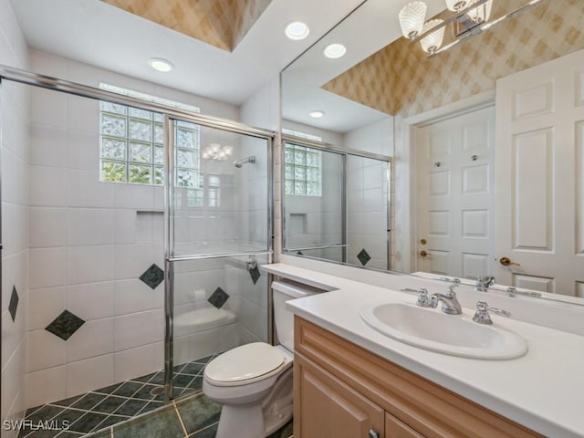 bathroom with tile patterned flooring, vanity, walk in shower, and a wealth of natural light