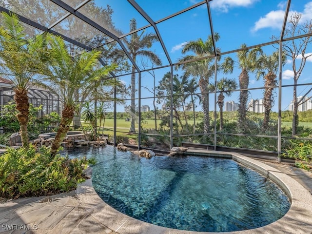 view of swimming pool featuring glass enclosure