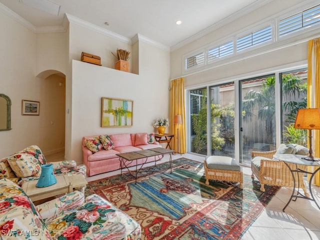 living room with light tile patterned floors, ornamental molding, and a high ceiling