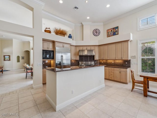 kitchen featuring a center island, light brown cabinets, built in appliances, crown molding, and light tile patterned floors