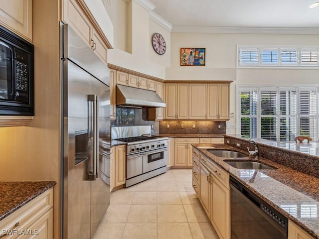 kitchen featuring sink, backsplash, dark stone countertops, light tile patterned floors, and black appliances