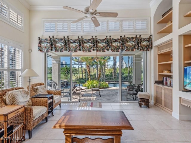 tiled living room featuring built in features, ceiling fan, and ornamental molding