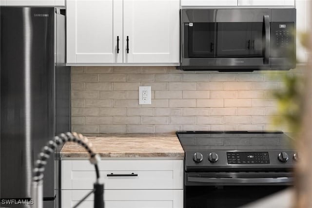 kitchen featuring decorative backsplash, appliances with stainless steel finishes, and white cabinets